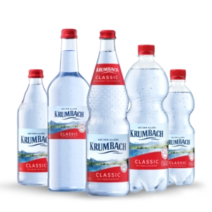 Fünf Krumbach Classic Flaschen mit Kohlensäure in Glas und PET, nebeneinander auf weißem Hintergrund
