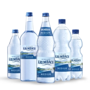 Fünf Krumbach Medium Flaschen mit wenig Kohlensäure in Glas und PET, nebeneinander auf weißem Hintergrund