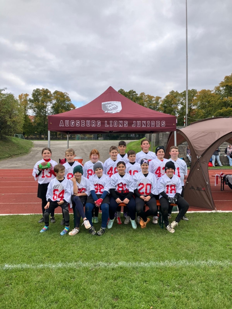 Kinderteam der Augsburg Lions Juniors vor einem Pavillon auf dem Sportplatz im Rahmen der Krumbach Gewünscht Gemacht Aktion