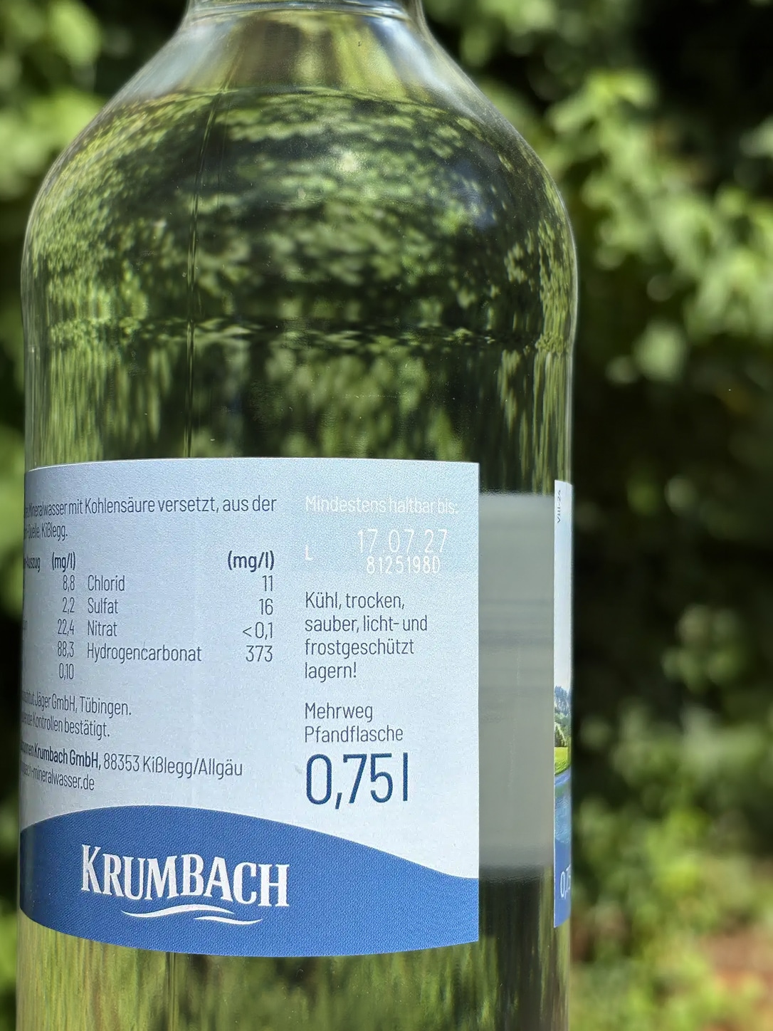 Nahaufnahme einer Krumbach 0,75-Liter-Glasflasche mit Etikett und aufgedrucktem Mindesthaltbarkeitsdatum