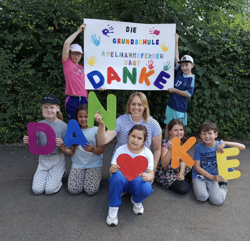 Kinder und Klassenlehrerin der Grundschule bedanken sich mit einem Plakat